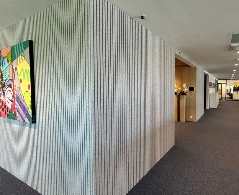 Mur acoustique en feutre rainuré dans un couloir de bureaux